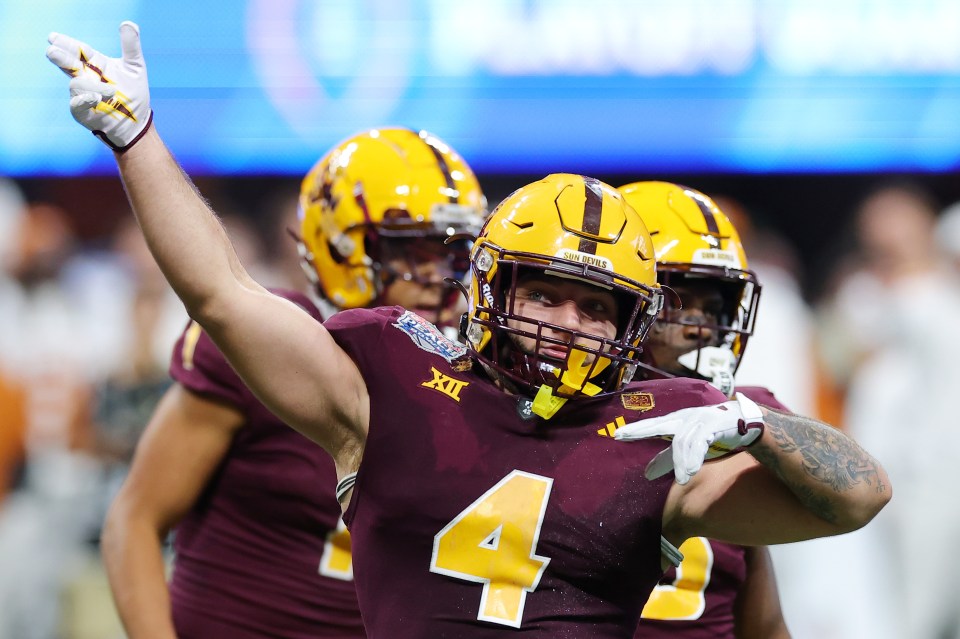 You are currently viewing Rising NFL Draft star poses with doppelganger dad after monster statline follows bizarre sideline vomiting incident